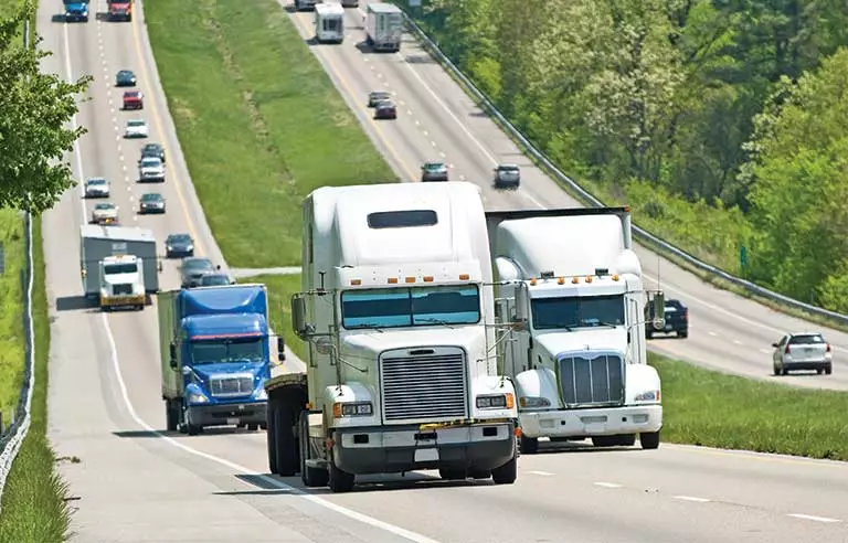 Fleet of trucks on a highway.